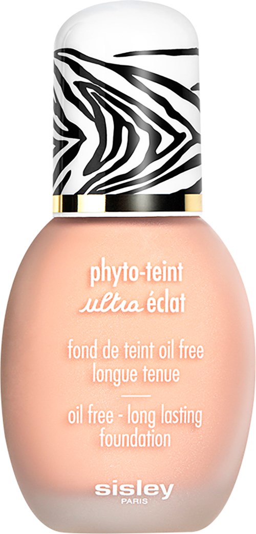 Een foundationfles met zebra-achtig deksel, roze vloeistof en witte tekst.