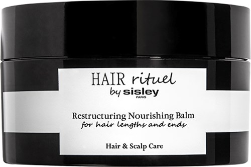 Ein schwarz-weißer Behälter mit Aufschrift 'Hair Ritual by Sisley' für Haarpflege und pflegendes Balm.