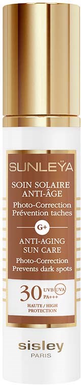 Een witte fles met gouden dop, gemarkeerd voor zonbescherming, anti-aging en het voorkomen van donkere vlekken met SPF 30.