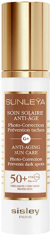 Een witte zonnebrandfles met een gouden dop, gemarkeerd voor anti-veroudering en zonbescherming, SPF 50+.