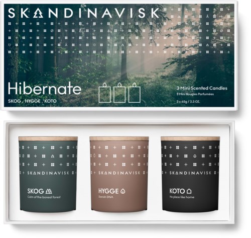 Set aus drei Kerzen in verschiedenen Farben, mit den Bezeichnungen Skog, Hygge, Koto, und Waldszene auf der Verpackung.
