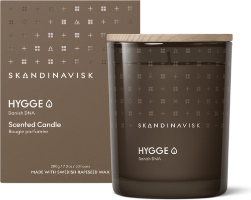 Ein Duftkerze mit grauem Glasgefäß und Holzkopf, unterstützt die Marke Skandinavisk und Danish DNA.