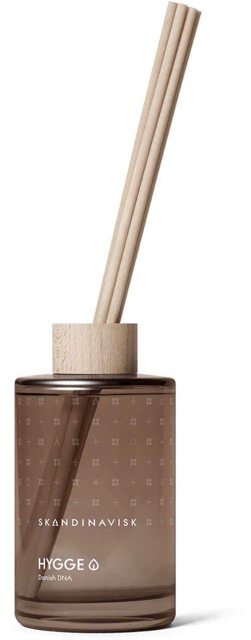 En brun glassbeholder holder tre trepinner, merket 'Skandinavisk Hygge' og 'Danish DNA' med to pinner inni.