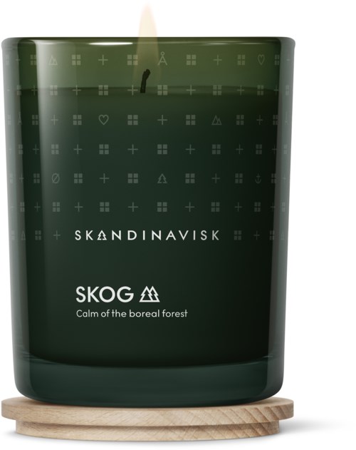 Eine dunkelgrüne Kerze mit der Aufschrift Skandinavisk Skog, beschreibt Ruhe im borealen Wald, auf einem Holzsockel.