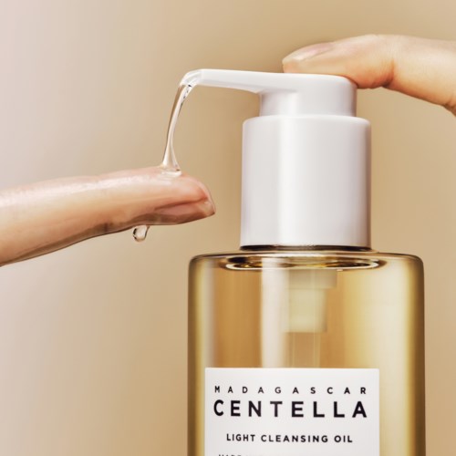 Eine Hand drückt auf eine Pumpe an einer transparenten Flasche Madagascar Centella leichte Reinigungsöl.
