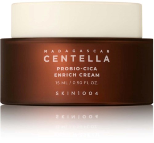 Ett brunt glasburk med vit lock, märkt 'Madagascar Centella Probio-Cica Enrich Cream,' innehåller 15 ml hudkräm.