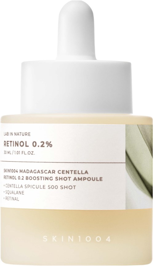 A bottle of skincare serum with a white dropper cap, label showing retinol concentration and ingredients from Skin 1004.