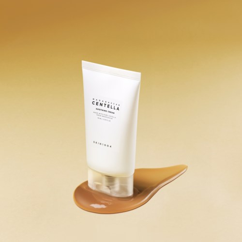 Eine Schachtel mit einer Naturaufnahme von Felsen und Gras, werbt für Madagascar Centella beruhigende Creme aus pflanzlichen Zutaten.