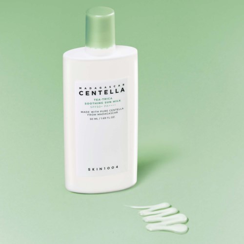 Weiße Flasche Madagascar Centella beruhigende Sonnenspray mit hellgrünem Deckel, und etwas weiße Creme an der Oberfläche.