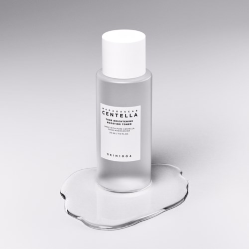 Kleine Flasche mit weißem Deckel und Etikett, auf einer Wasserlache. Etikett sagt 'Centella.'