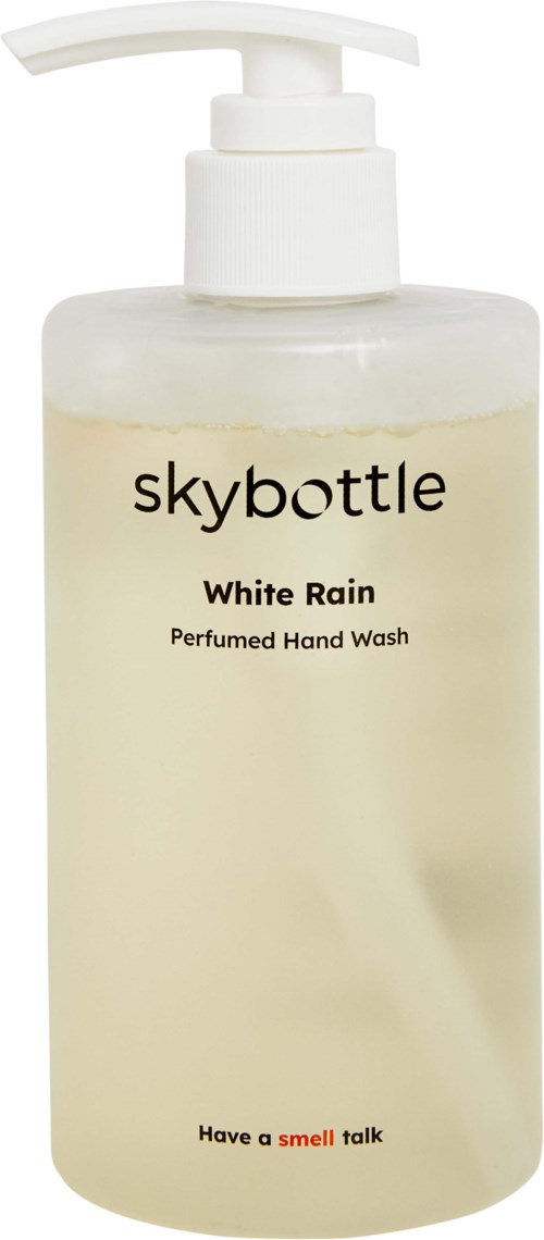 En vit flaska med pump innehåller handtvätt kallad White Rain, doftande, med märket Skybottle. Etiketten nämner doftprat.