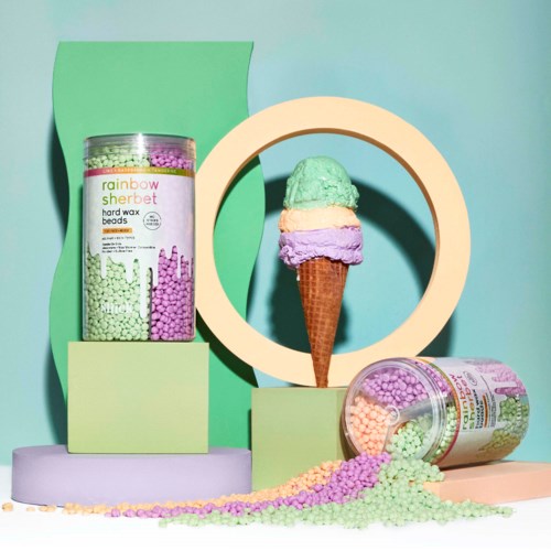 Bunte Süßigkeitenperlen und ein Eis mit Pastellkugeln. Heller Hintergrund mit Grün- und Lilatönen.