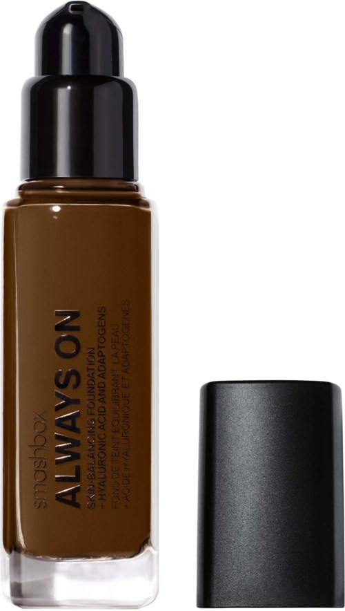 A brown liquid foundation bottle with a black cap and a separate black lid.