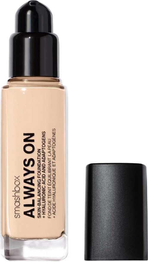 En flaske med Smashbox Always On foundation med svart hette ved siden av. Foundationen er beige.