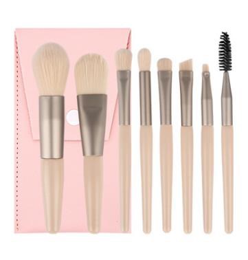 Set of eight makeup brushes in pink holder, varying sizes and shapes for different makeup tasks.