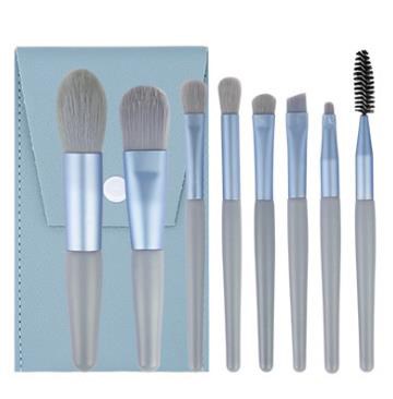 Set of makeup brushes with blue handles, varying sizes, arranged on a surface.