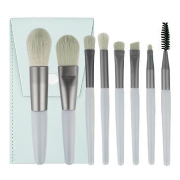 Set of seven makeup brushes with white handles and silver ferrules, ranging from large to small, including a spoolie.