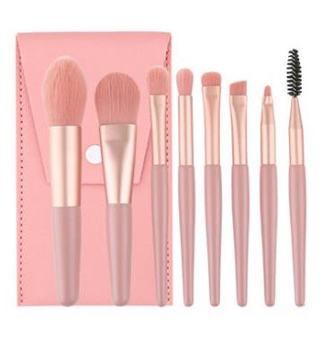 A set of eight pink makeup brushes, two in a pink box, with soft bristle heads and various shapes.
