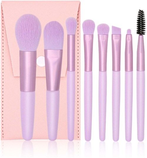 A set of seven pink makeup brushes with white handles, including powder, blush, eye shadow, eyeliner, eyebrow, and mascara brushes.