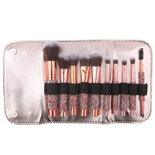 A set of makeup brushes in a pink case, with various sizes and shapes, some with glittery handles.