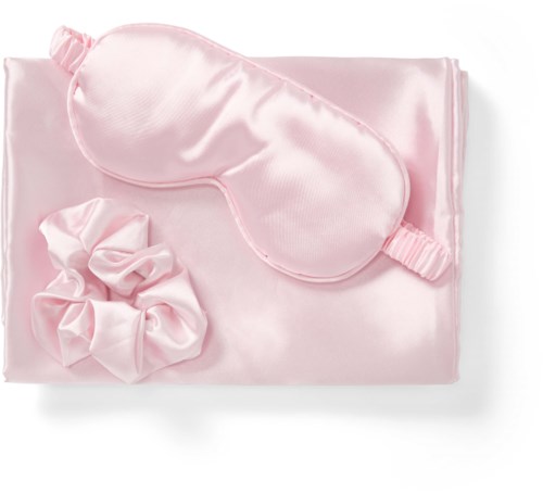 Pink satin sleep mask, matching silk scrunchie, and cloth. All items are soft and shiny.