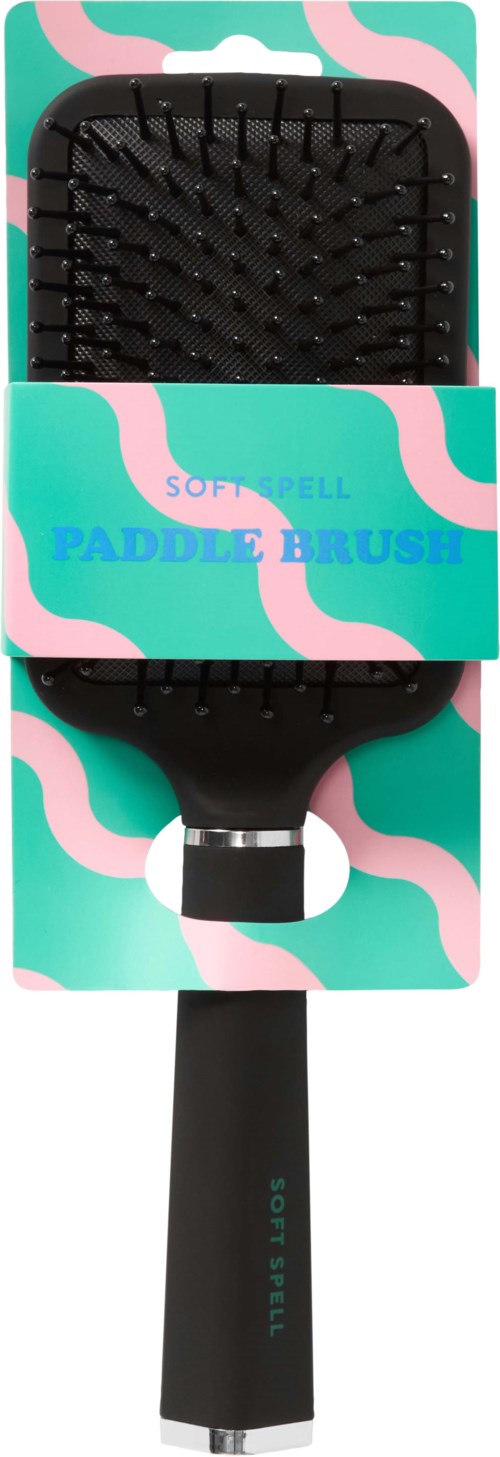 A soft spell paddle brush with a black handle and a wide brushing head, on colorful packaging displaying the product name.