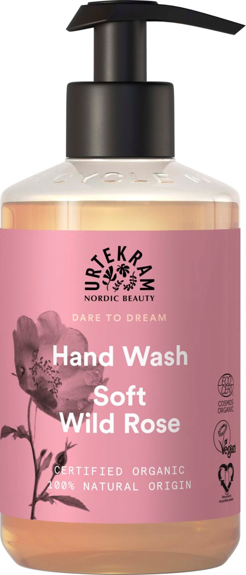 A pink bottle with a black pump, labeled 'Hand Wash Soft Wild Rose,' and symbols indicating organic and natural ingredients.