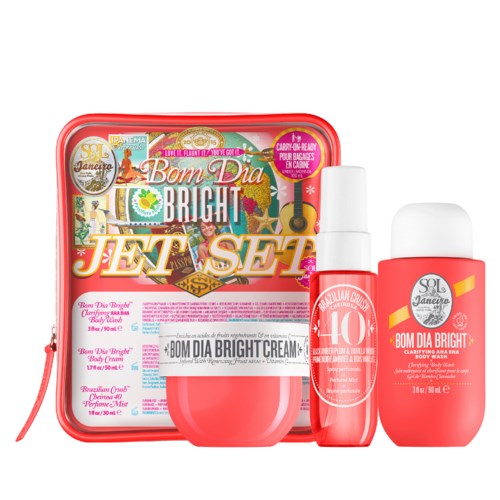 Ein hellrotes Schönheitsset enthält Creme, Spray und eine Tasche mit bunten Etiketten und Text.