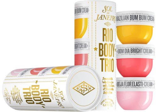 Set med tre färgglada burkar med kroppsskrämer, guld- och rosa förpackning, märkta som Rio Body Trio och Bum Cream.