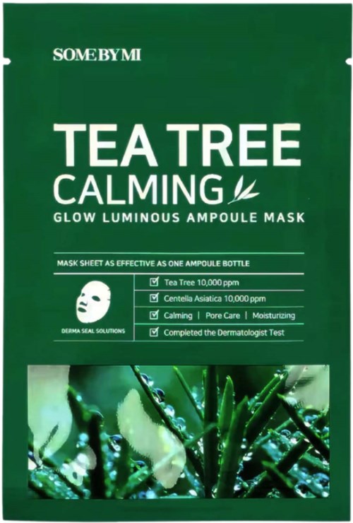 Grønn emballasje med hvit tekst for en te-treet beroligende maske, med en bladlogo og bilde av te-tre planter.