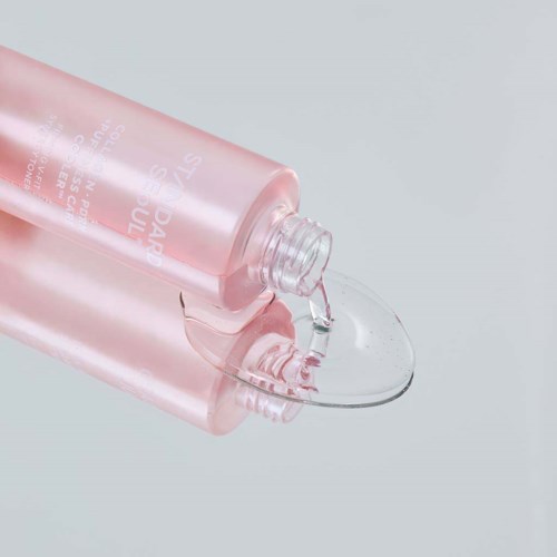Pink bottle pouring clear liquid onto a surface.