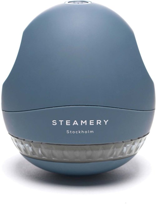 En blå enhet med ordena "STEAMERY Stockholm" på. Ser ut som ett litet, runt föremål med en tydlig bas.