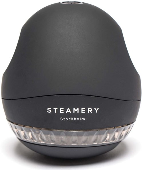 Ein schwarzes, rundes Gerät mit einem klaren Boden. Es trägt die Worte 'STEAMERY Stockholm'.