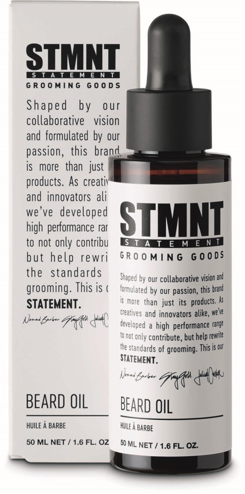 A black bottle with a dropper and a label, placed next to a box. The label says 'STMT Statement Grooming Goods' and 'Beard Oil.'