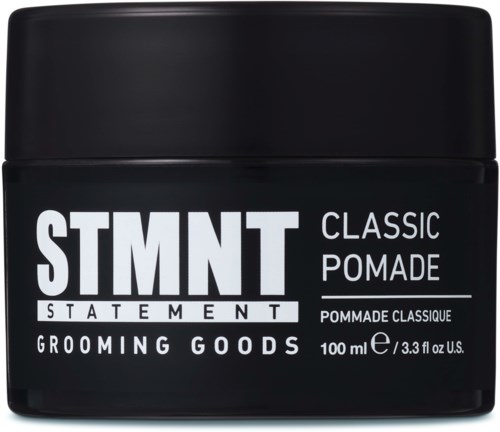 A black container with white text, labeled "STMNT Classic Pomade," holding 100 ml of grooming product.