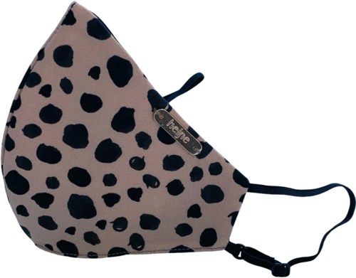 En ansiktsmask med beige bakgrund och svarta oregelbundna fläckar, fästad med svarta band.