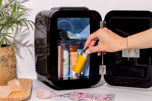 Eine Person nimmt eine gelbe Sprühflasche aus einem Sterilisator auf einer Theke.