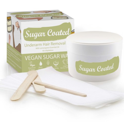 Vegan sugar wax for hair removal, with lemon grass oil, in a jar and wooden spatulas.