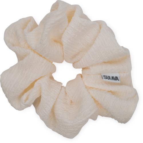Elfenbeinfarbener Stoff-Haarreif mit kleinem SUI AVA-Label, weich und gerafft, in kreisförmiger Form.
