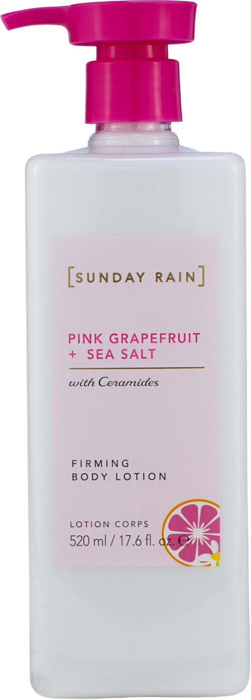 En hvit lotionflaske med rosa pumpe og etikett for Pink Grapefruit og Sea Salt kroppslotion fra Sunday Rain.