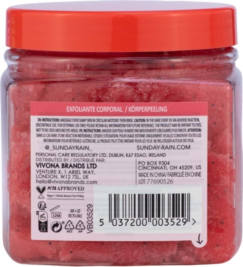 Rosa skrubb med exfolierande korn i en klar burk med rosa etikett och orange lock.
