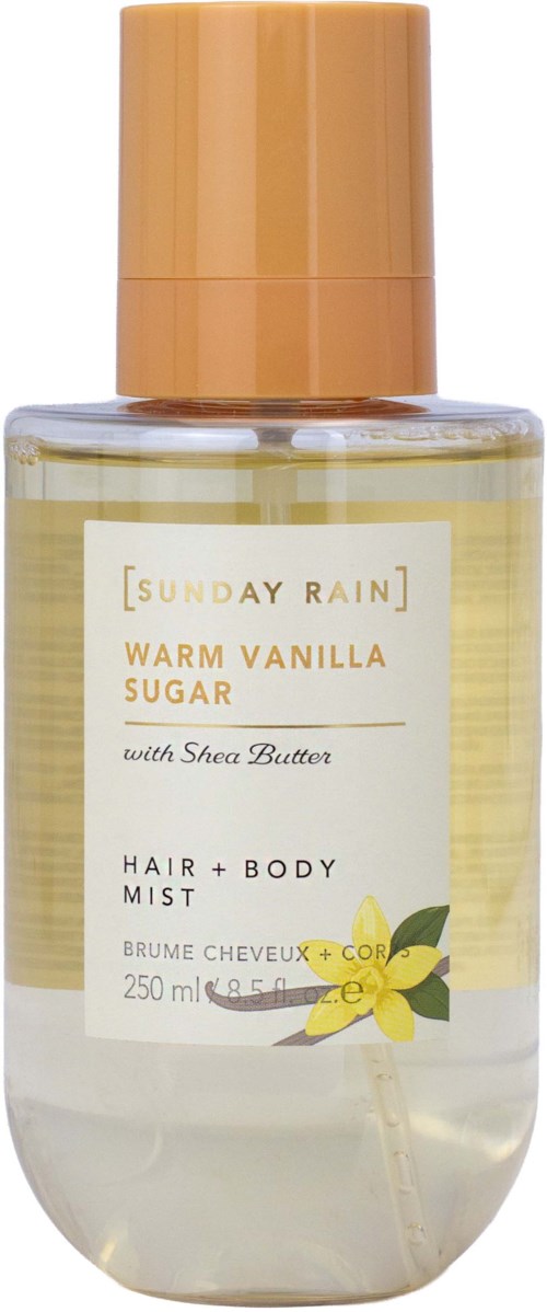 En gjennomsiktig flaske med Sunday Rain Warm Vanilla Sugar hår- og kroppsspray med beige lokk, gul vaniljblomst og etikett.