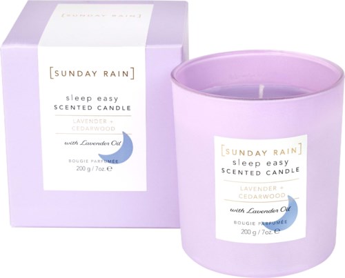 Lavendel og sedertreduftende lys i en lilla beholder med eske, merket Sunday Rain sleep easy.