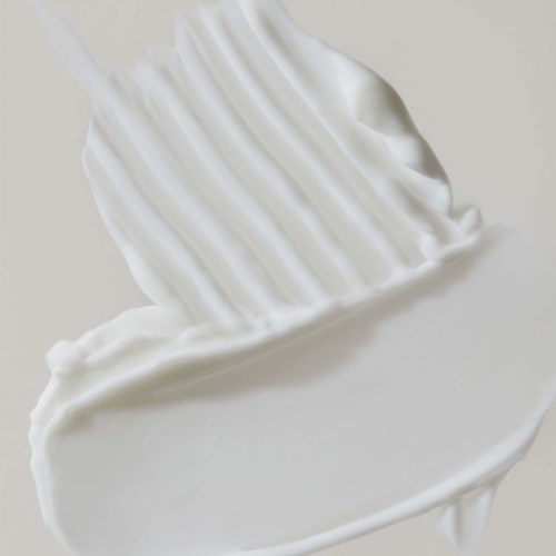 En klick av vit vispgrädde eller frosting med ett texturerat toppskikt och slät botten.