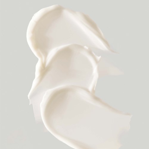 Three white creamy dollops of yogurt or cream on a light background.