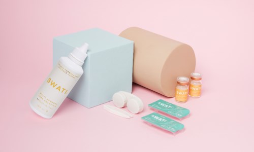 Huidverzorgingsproducten inclusief een fles, twee kleine potjes, wattenschijfjes en doekjes met pastelachtergrond.