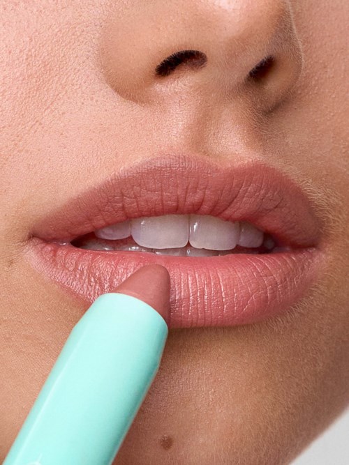 Close-up of lips with someone applying lip balm or lipstick.