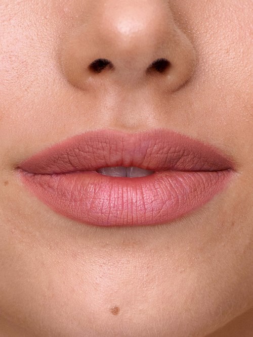 Close-up of lips, with skin showing around nose and mouth, natural makeup, neutral expression.