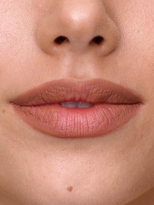 Close-up of a woman's lips and part of her nose, with natural skin texture and minimal makeup.