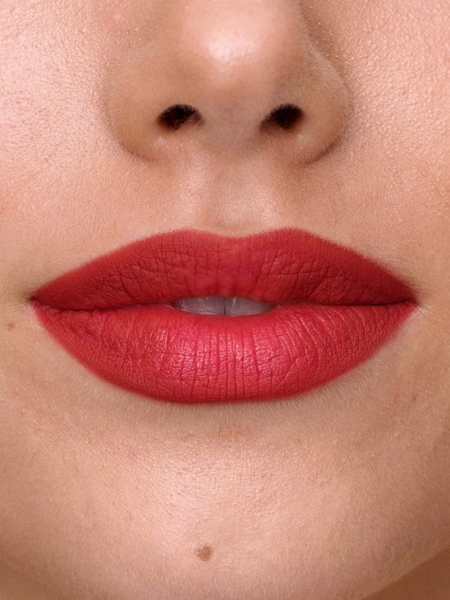 Close-up of a person's lips with red lipstick and skin detail.